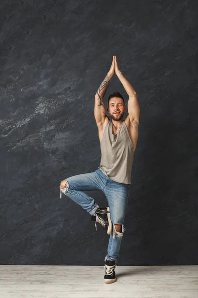 Glücklich gut aussehender Mann macht eine Yoga-Pose im Studio — Stockfoto