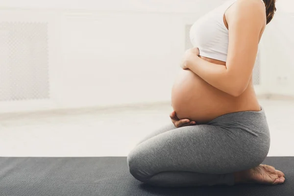 Mulher grávida irreconhecível treinando ioga em pose de lótus — Fotografia de Stock