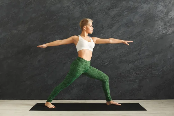 Mujer entrenando yoga pose en gimnasio — Foto de Stock