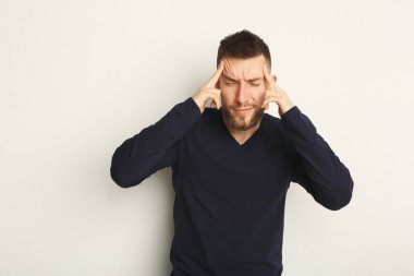 Onun tapınaklar dokunmaktan ve baş ağrısı olan sakallı genç adam