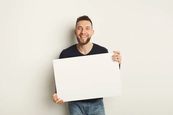 Joven barbudo con papel blanco en blanco — Foto de Stock