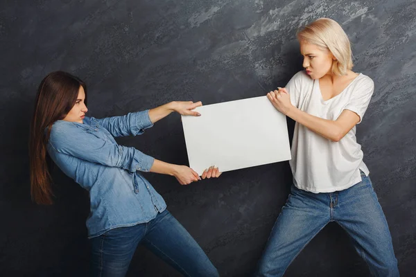 Chicas felices con pancarta blanca en blanco en el fondo del estudio oscuro —  Fotos de Stock