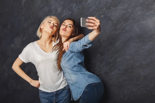 Dos mujeres felices tomando selfie en el fondo del estudio — Foto de Stock