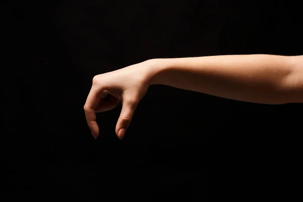 何か、黒の切り欠きを拾う女性の手 — ストック写真