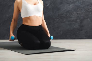 Halter gri arka plan üzerinde tutan tanınmaz fitness kadın