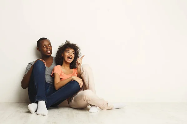 Cuplu afro-american care se uită în sus, stând pe podea — Fotografie, imagine de stoc