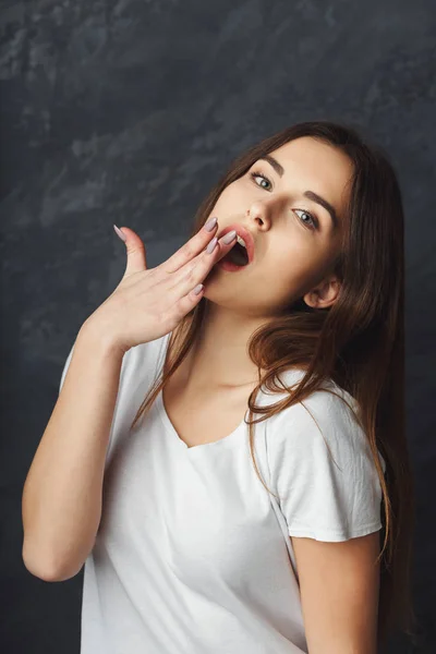 Mujer joven bostezando sobre fondo oscuro — Foto de Stock