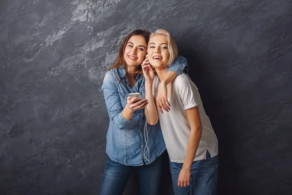 Happy women friends listen to music at studio background — стоковое фото