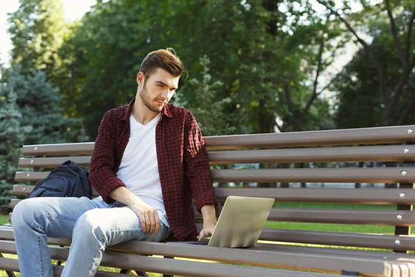 Hombre concentrado trabajando en su portátil al aire libre — Foto de Stock