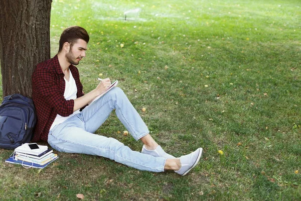 Joven escribiendo en copy-book al aire libre —  Fotos de Stock