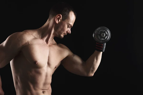 Сильный спортсмен с гантелями демонстрирует обнаженное мускулистое тело — стоковое фото