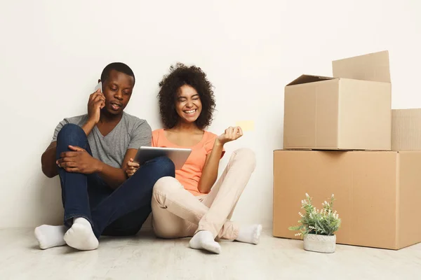 Afro-americano sentado no chão no novo apartamento — Fotografia de Stock