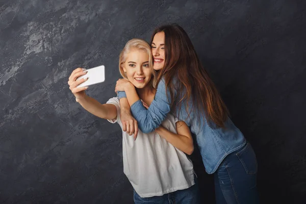 Dwie kobiety szczęśliwy biorąc selfie w studio tło — Zdjęcie stockowe