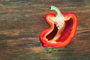 Bir ahşap masa üzerinde olgunlaşmış taze kırmızı biber kesmek