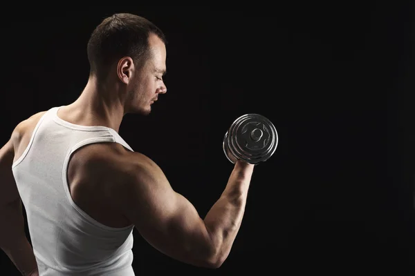 Hombre atlético fuerte con mancuerna muestra el cuerpo muscular — Foto de Stock