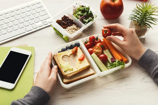 妇女吃健康三明治从午餐盒在她的工作桌 — 图库照片