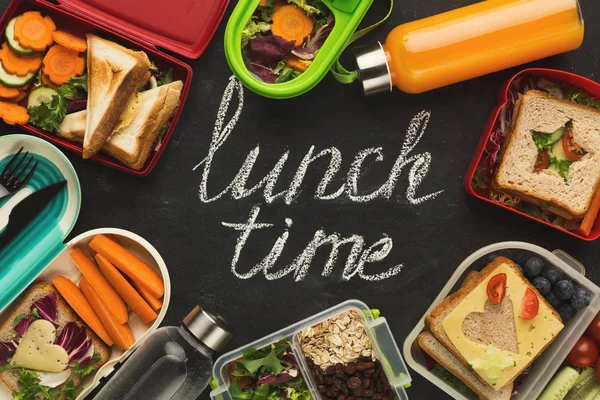Lunch boxes filled with healthy food on black board — Stock Photo, Image