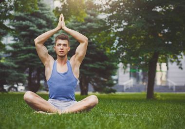 Pratik yoga padmasana içinde oturan genç adam