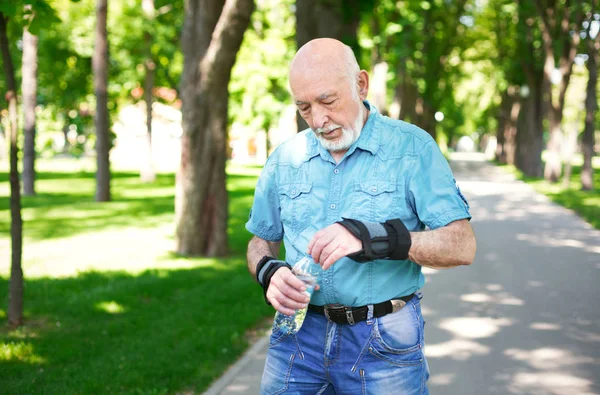 Äldre mannen i fritidskläder med vattenflaska — Stockfoto