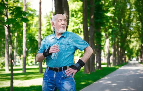 Senior in Freizeitkleidung mit Wasserflasche — Stockfoto