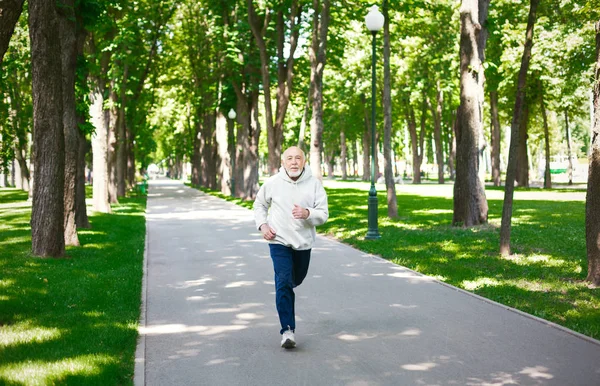Hombre mayor corriendo en el parque verde, espacio para copiar —  Fotos de Stock