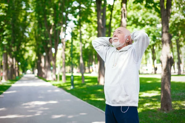Elderly man running in green park, copy space — Stock Photo, Image