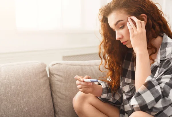 Worried girl reading the results of her pregnancy test — Stock Photo, Image