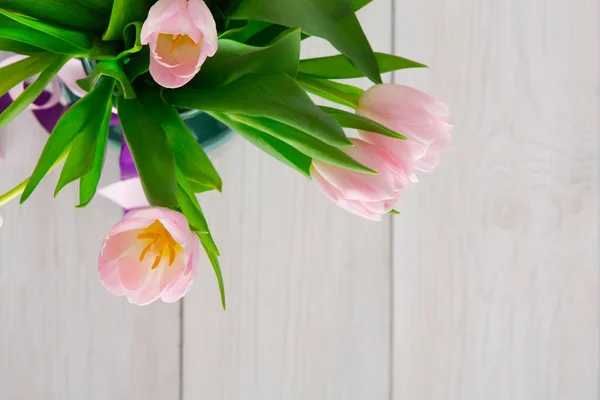 Buquê de tulipas rosa no fundo de madeira branca, vista superior — Fotografia de Stock