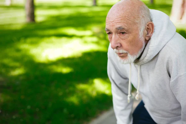 Elderly man running in green park, copy space — Stock Photo, Image