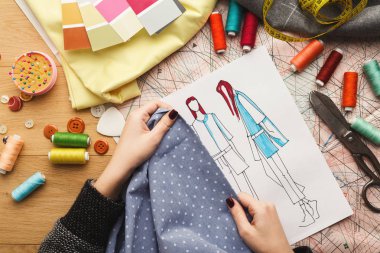 Kadın moda tasarımcısı kumaş örnek ve çizilen illüstrasyon ile çalışma