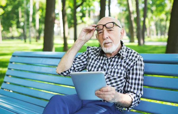 デジタル タブレットの屋外でカジュアルで年配の男性 — ストック写真