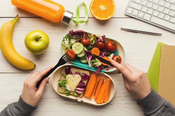 Femme mangeant sain dîner de la boîte à lunch à sa table de travail — Photo