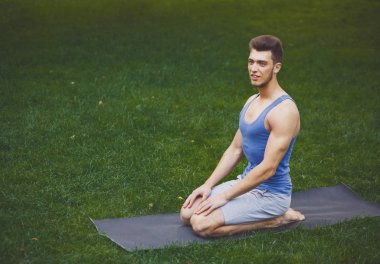 Eğitim yoga kahraman poz açık havada genç adam