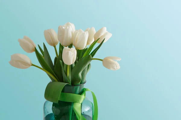 Букет білих тюльпанів на синьому фоні — стокове фото