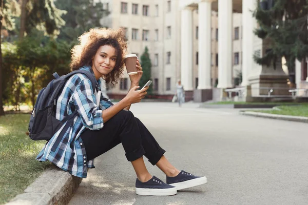 Student tjej med ryggsäck och mobil på Universitetshuset bakgrund — Stockfoto