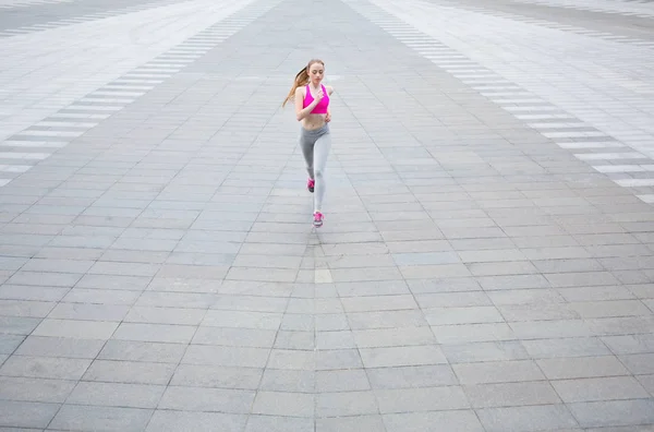 Young woman running in city copy space — Stock Photo, Image