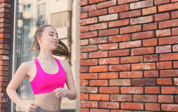 Young woman running in city copy space — Stock Photo, Image