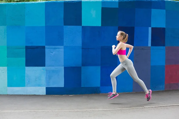 Young woman running in city copy space — Stock Photo, Image