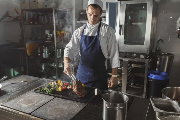 Chef cooking juicy beef steak at restaurant kitchen — Stock Photo, Image