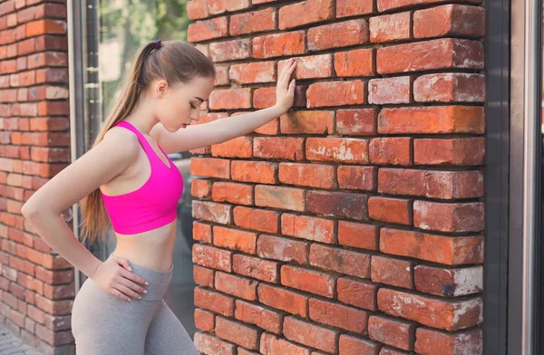 Pelirroja mujer apoyada en la pared de ladrillo — Foto de Stock