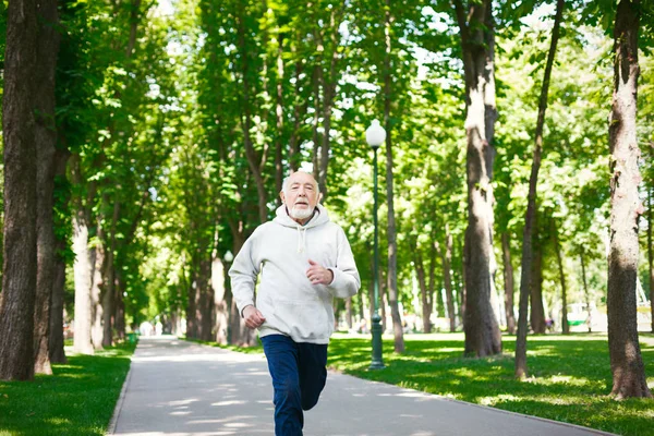 Hombre mayor corriendo en el parque verde, espacio para copiar —  Fotos de Stock