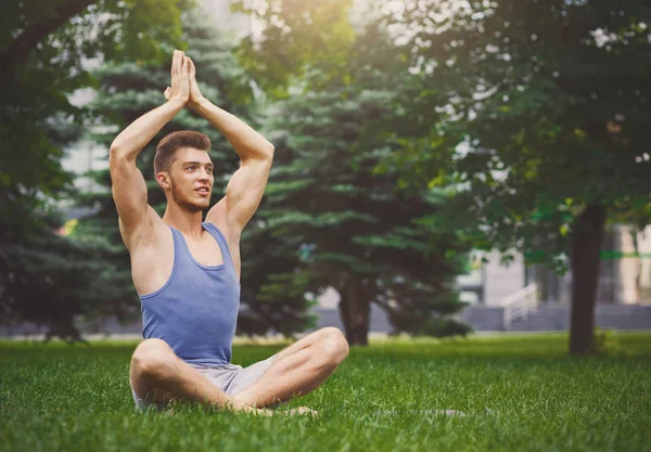 Young man practicing yoga sitting in padmasana — Stock Photo, Image