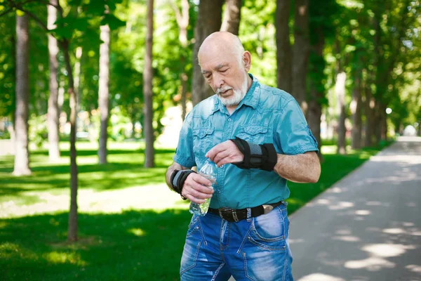 Äldre mannen i fritidskläder med vattenflaska — Stockfoto