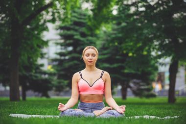 Genç kadın açık havada, sakin ol meditasyon poz