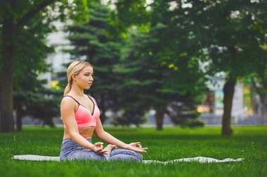 Genç kadın açık havada, sakin ol meditasyon poz