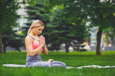 Pratik yoga padmasana içinde oturan genç çekici kadın