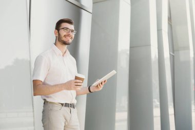 Gülümseyen işadamı açık havada tablet ile çalışma