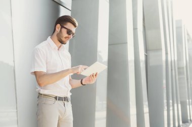 Gülümseyen işadamı açık havada tablet ile çalışma