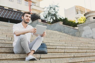 Dalgın işadamı açık havada tablet ile çalışma