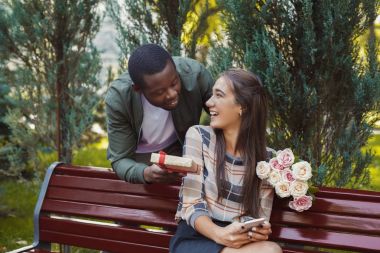 Çiçekler ve onun kız arkadaşı için hediye veren adam